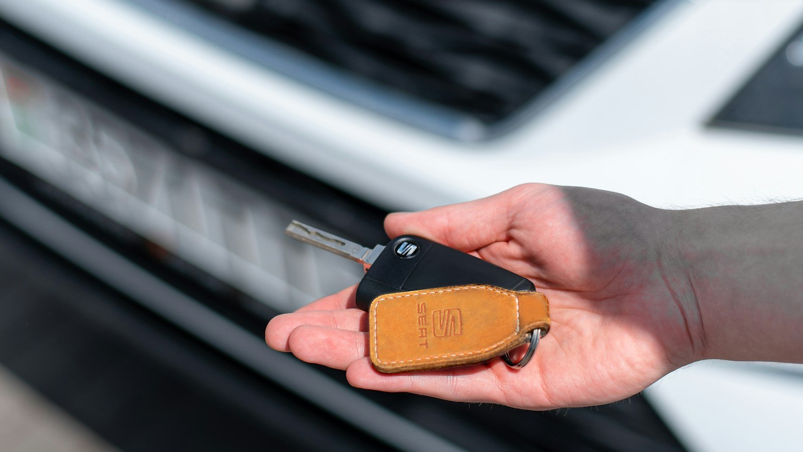 Person holding a car key in their hand