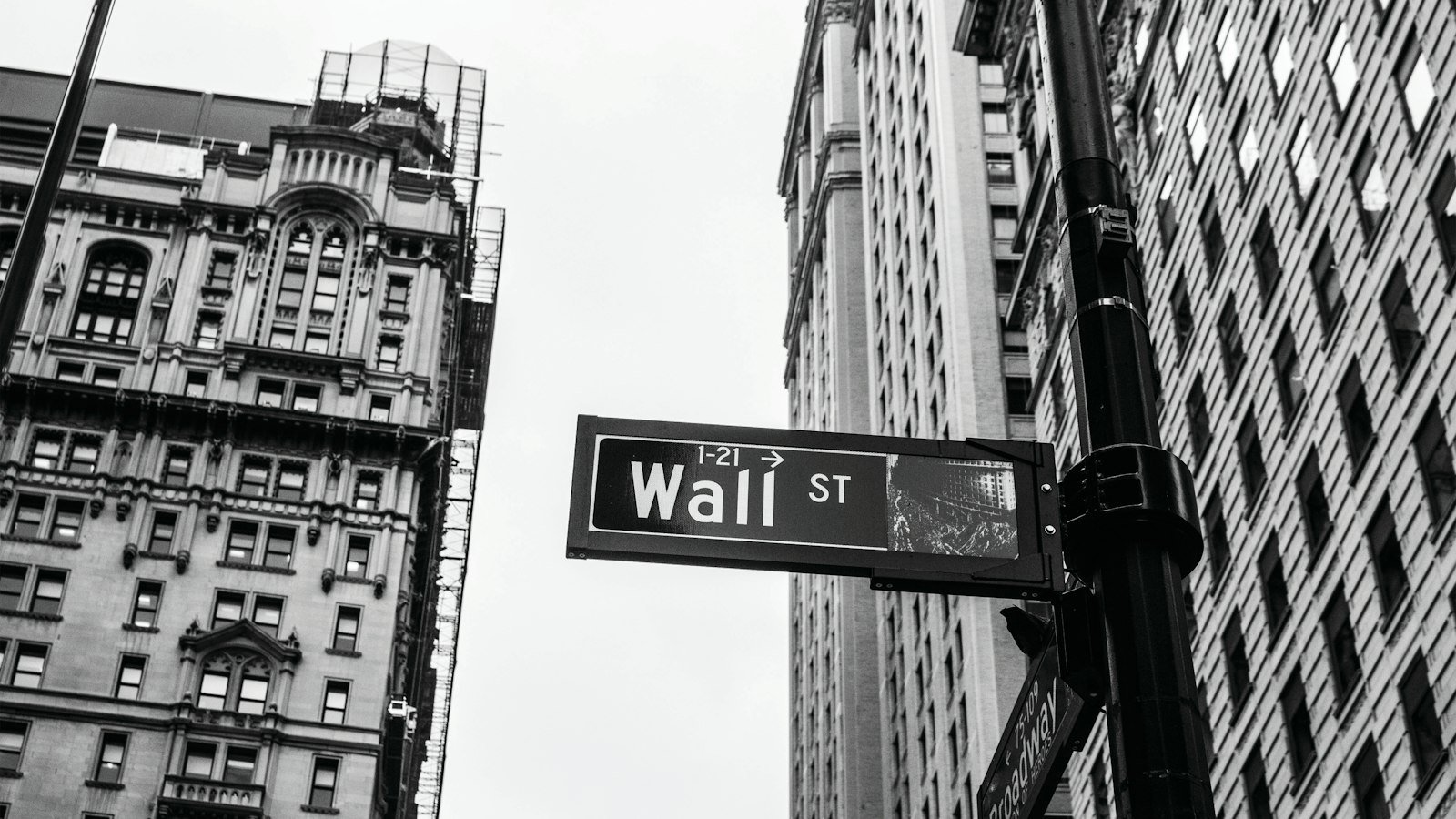 Grayscale photo of a Wall Street street sign in New York